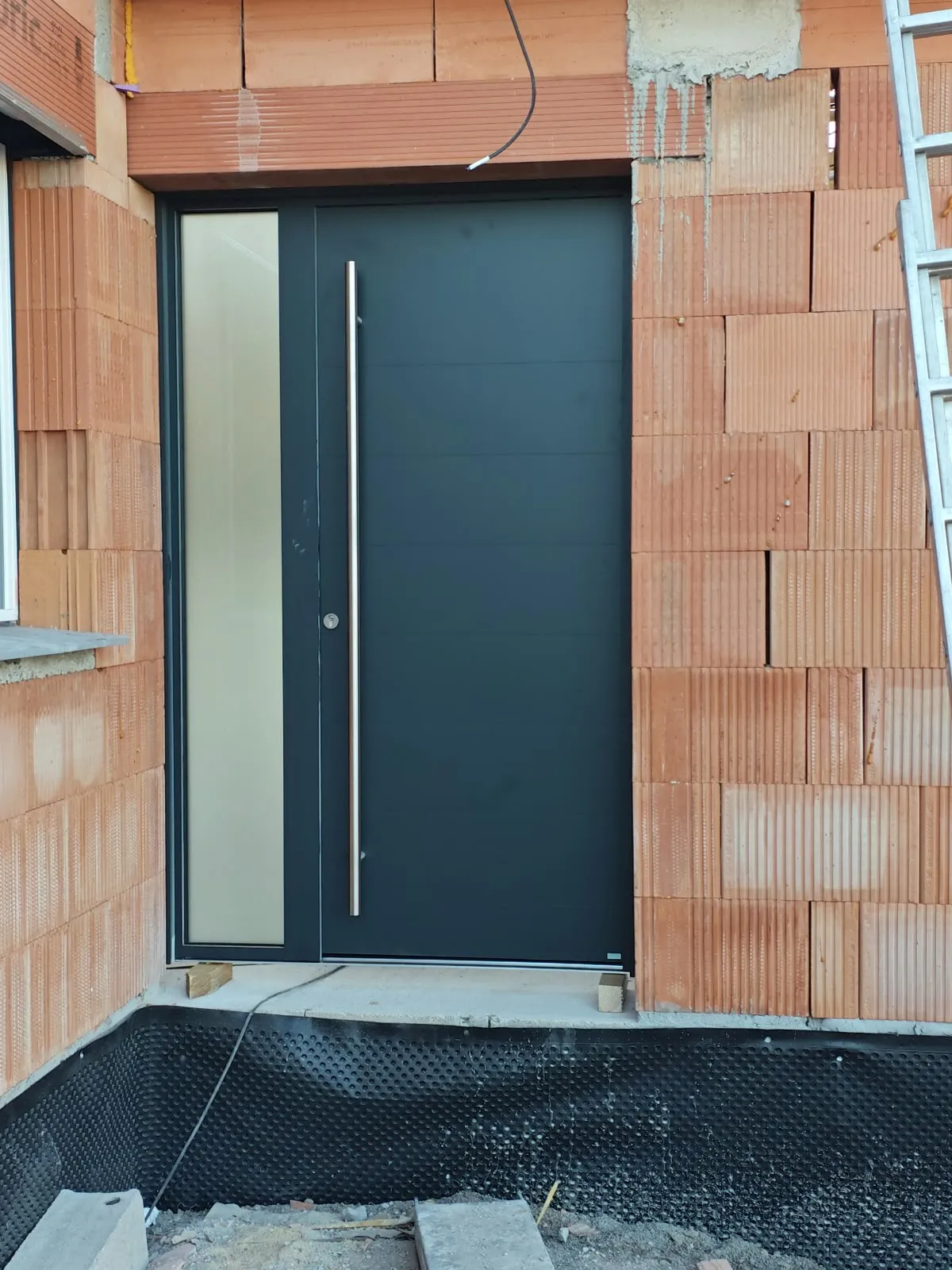 Porte d'entrée posée dans un mur en briques