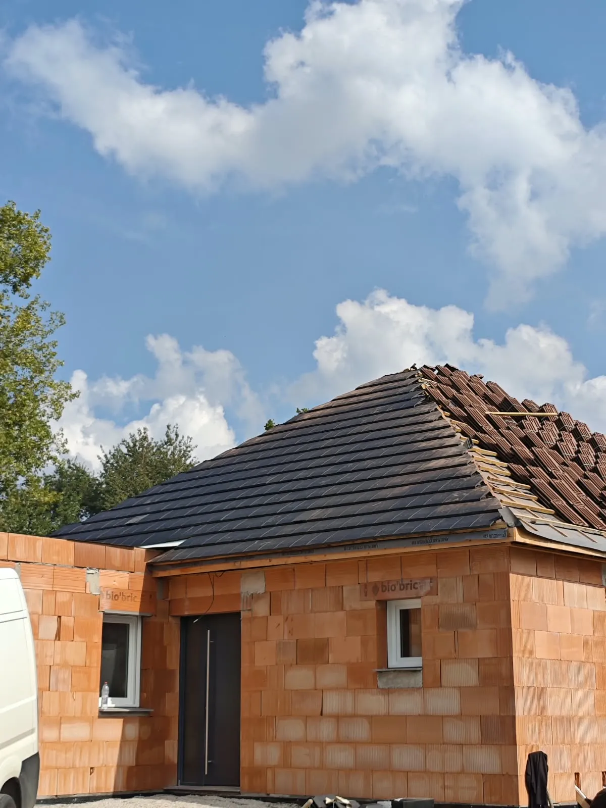 Construction d’une maison en briques avec toiture en cours de pose